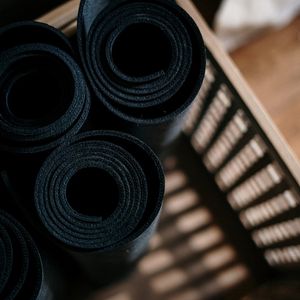 Hands holding a fitness mat rolled up tightly