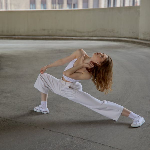 Person doing dynamic stretching movements in a bright room